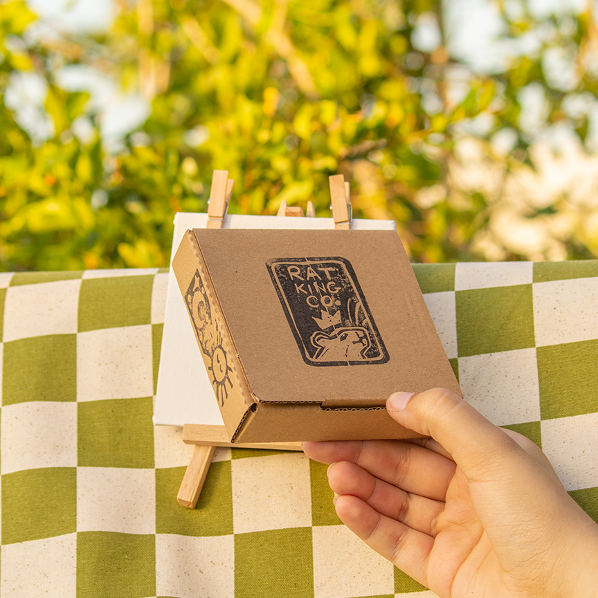 Brown cardboard box decorated with a Rat King Co stamp