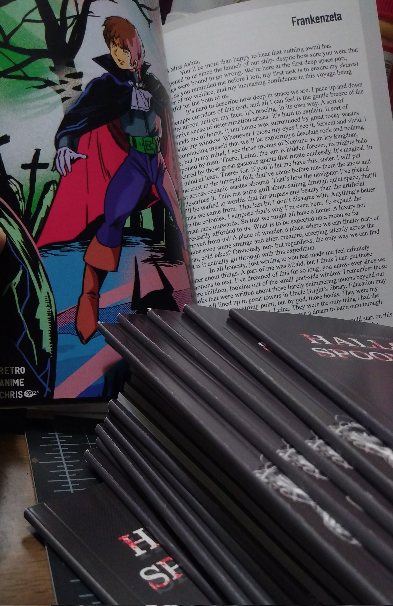 Pile of zines again, this time showing this perfect binding on the spine while one is propped open to show off the contents- a very beautiful illustration and the first page of the fanfiction 'Frankenzeta'