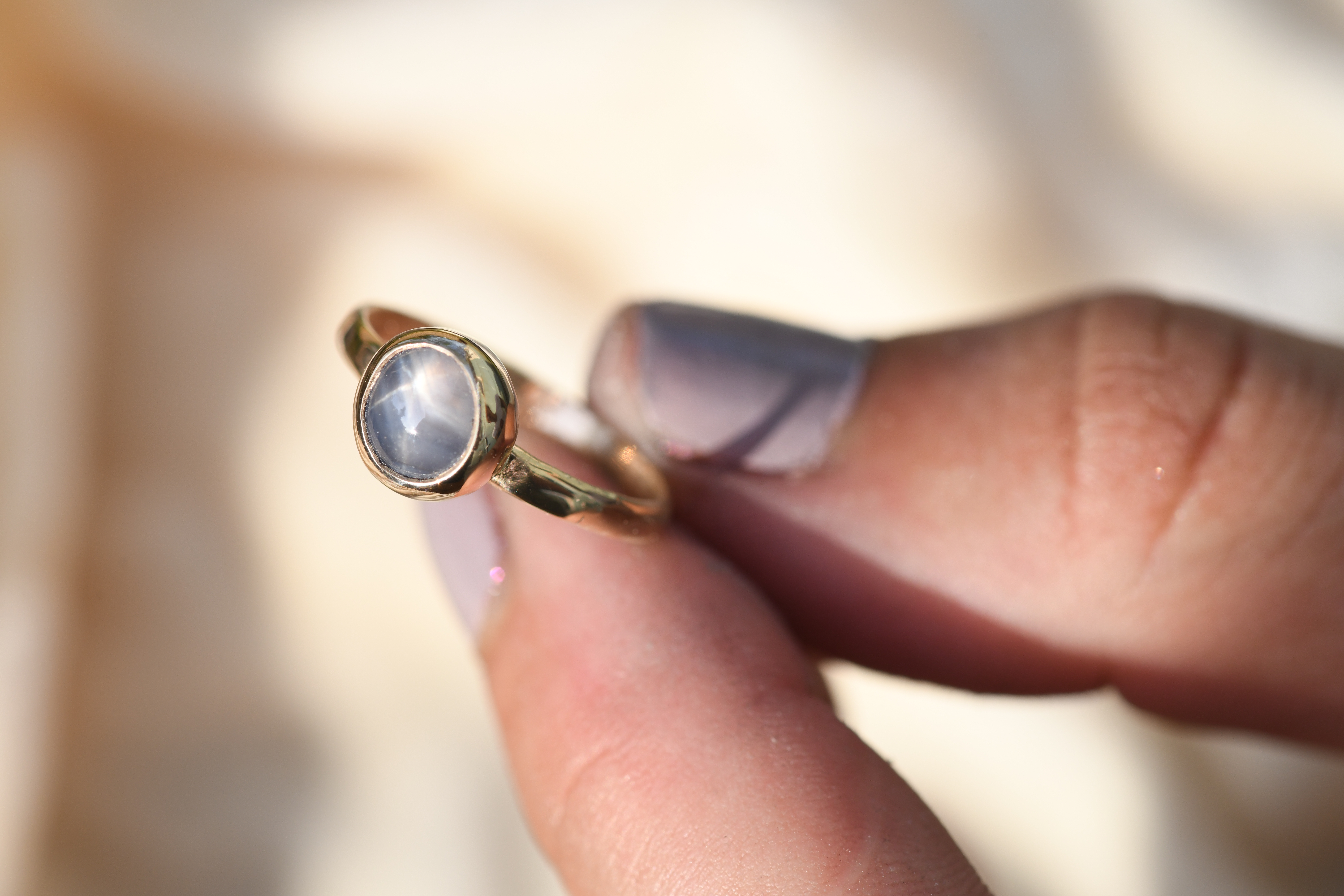 purple star sapphire bezel set in 14k gold with a hammered band