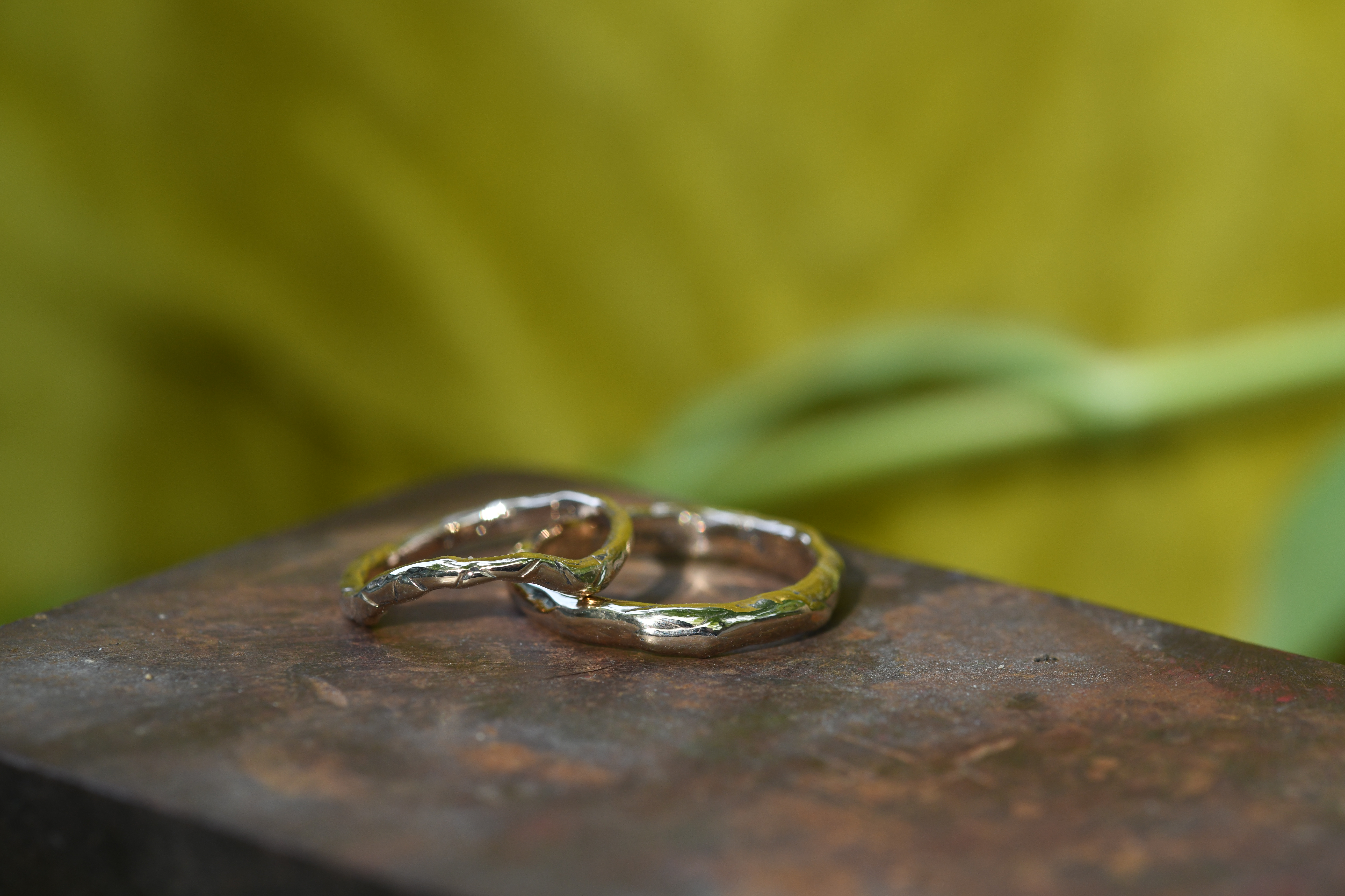 wedding bands cast in 14k gold, one with a slight curve as an engagement band, the texture mimicking the heirloom chain used to make the ring