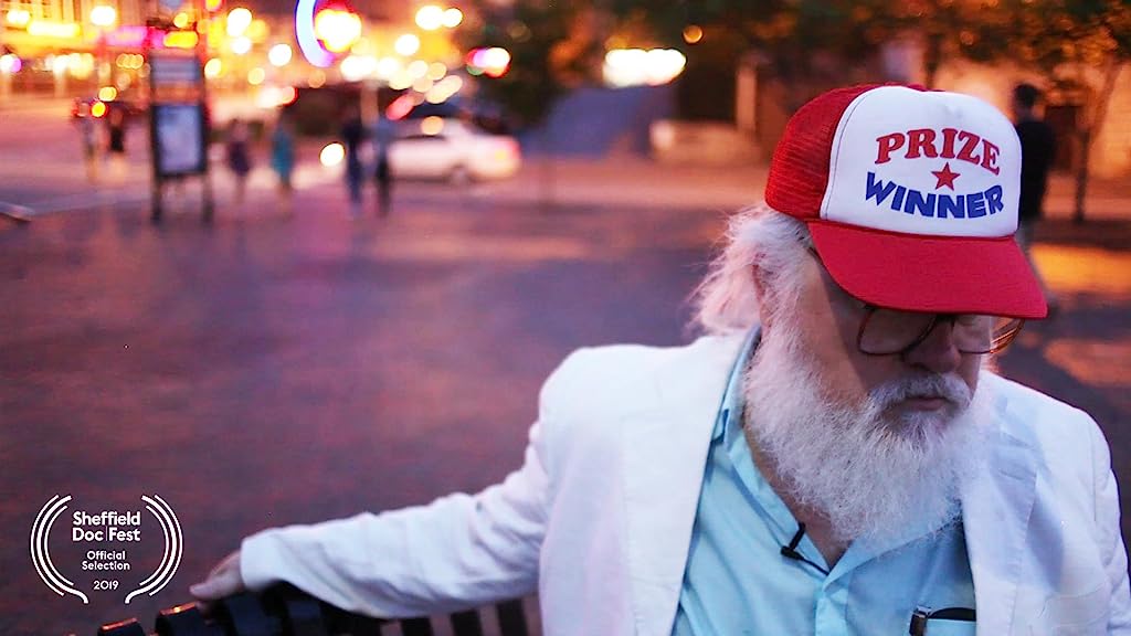R. Stevie Moore sits on a bench in Nashville wearing a prize winner hat, for the Cool Daddio documentary