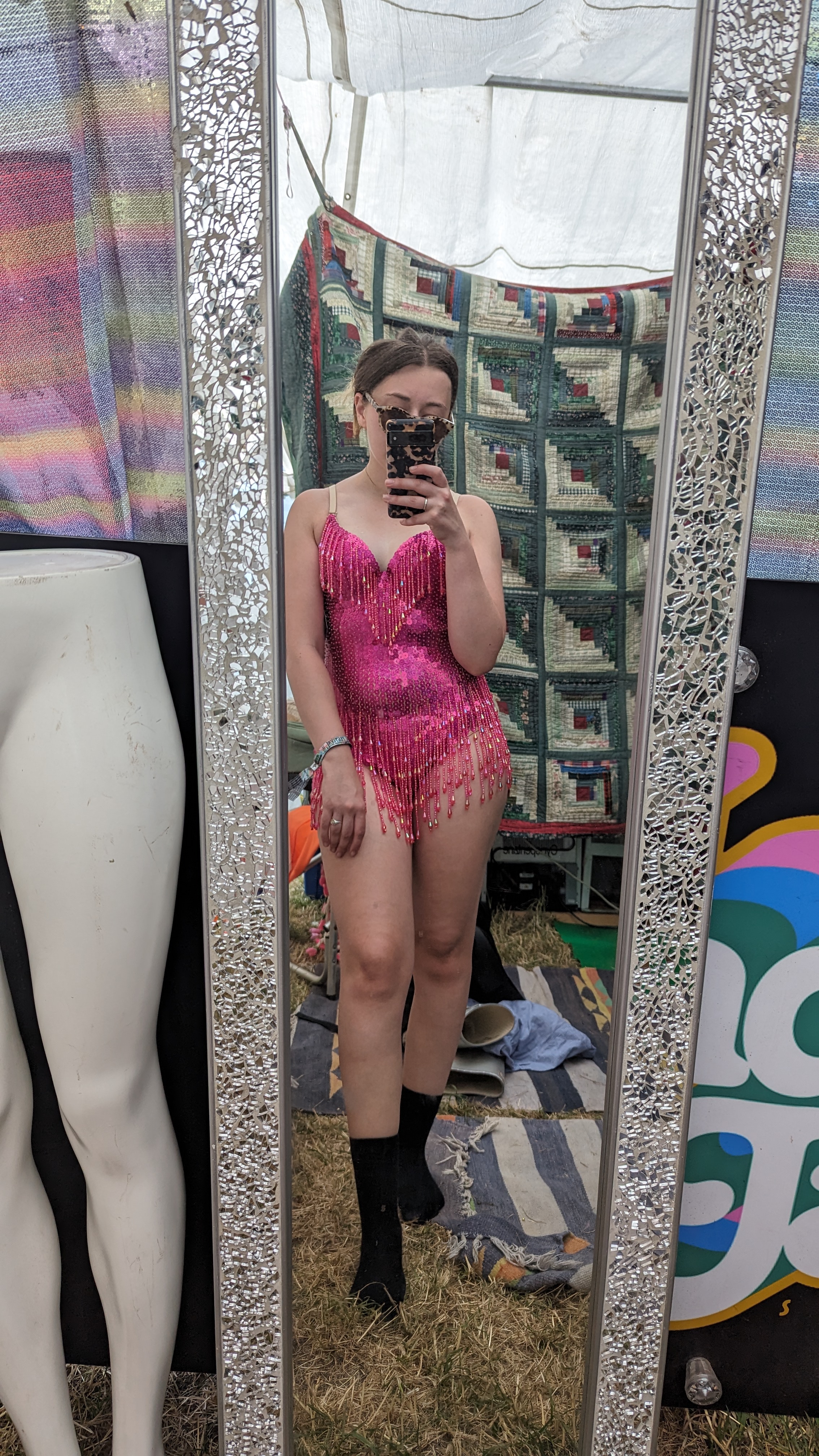Girl taking photo in mirror wearing a pink sequinned body suit with bead trim
