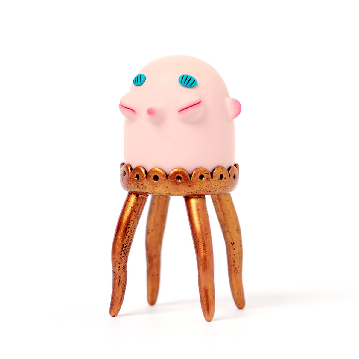 Polymer clay sculpture of a bald head with golden legs