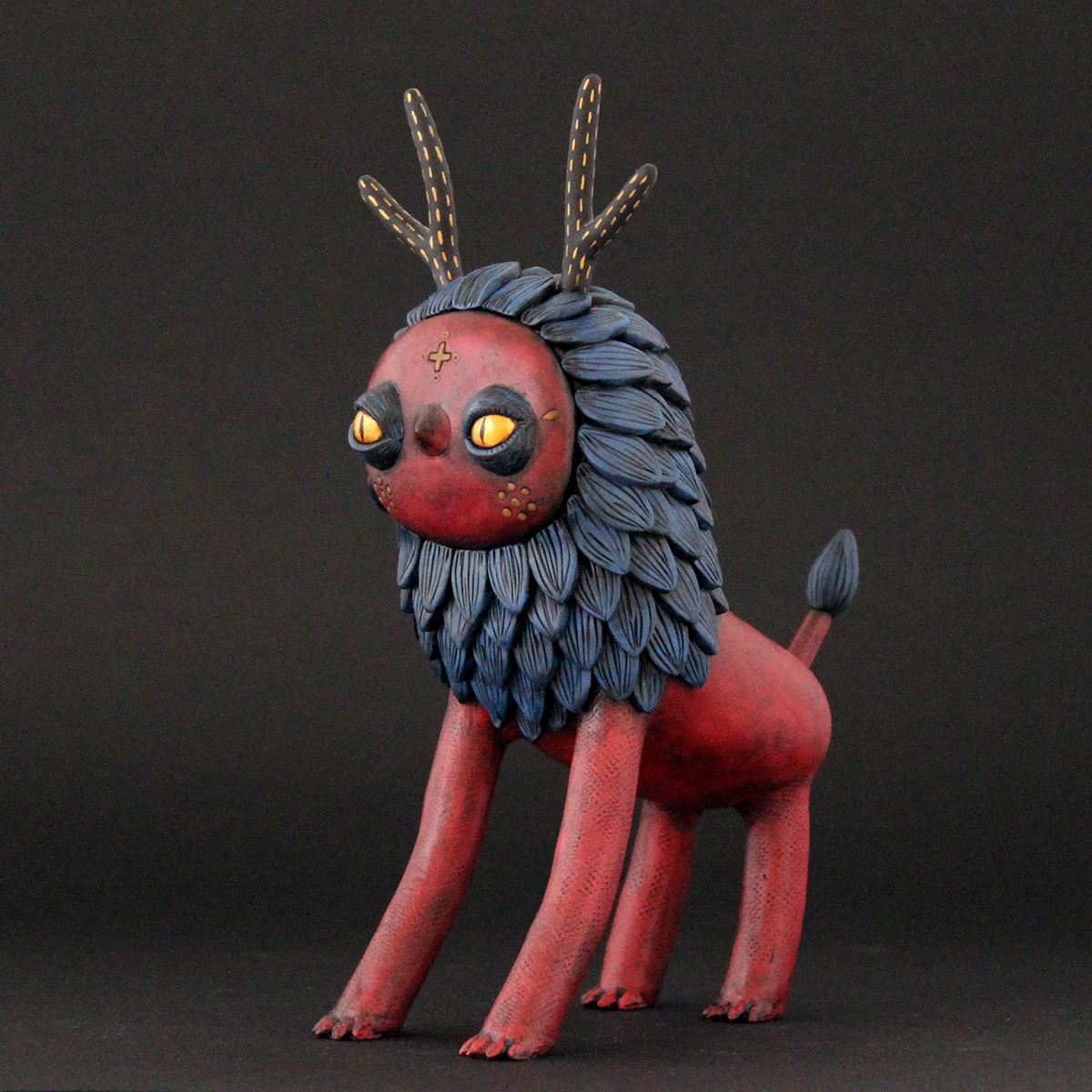Polymer clay sculpture of an imaginary creature in red and blue