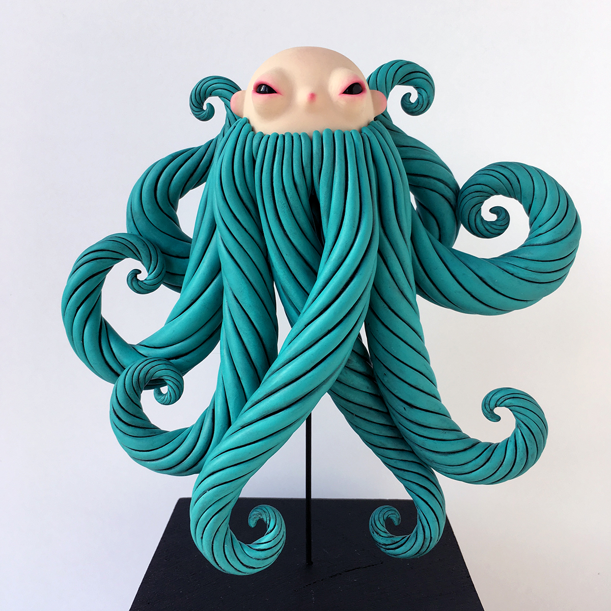 Sculpture of a creature half blue bearded man half octopus