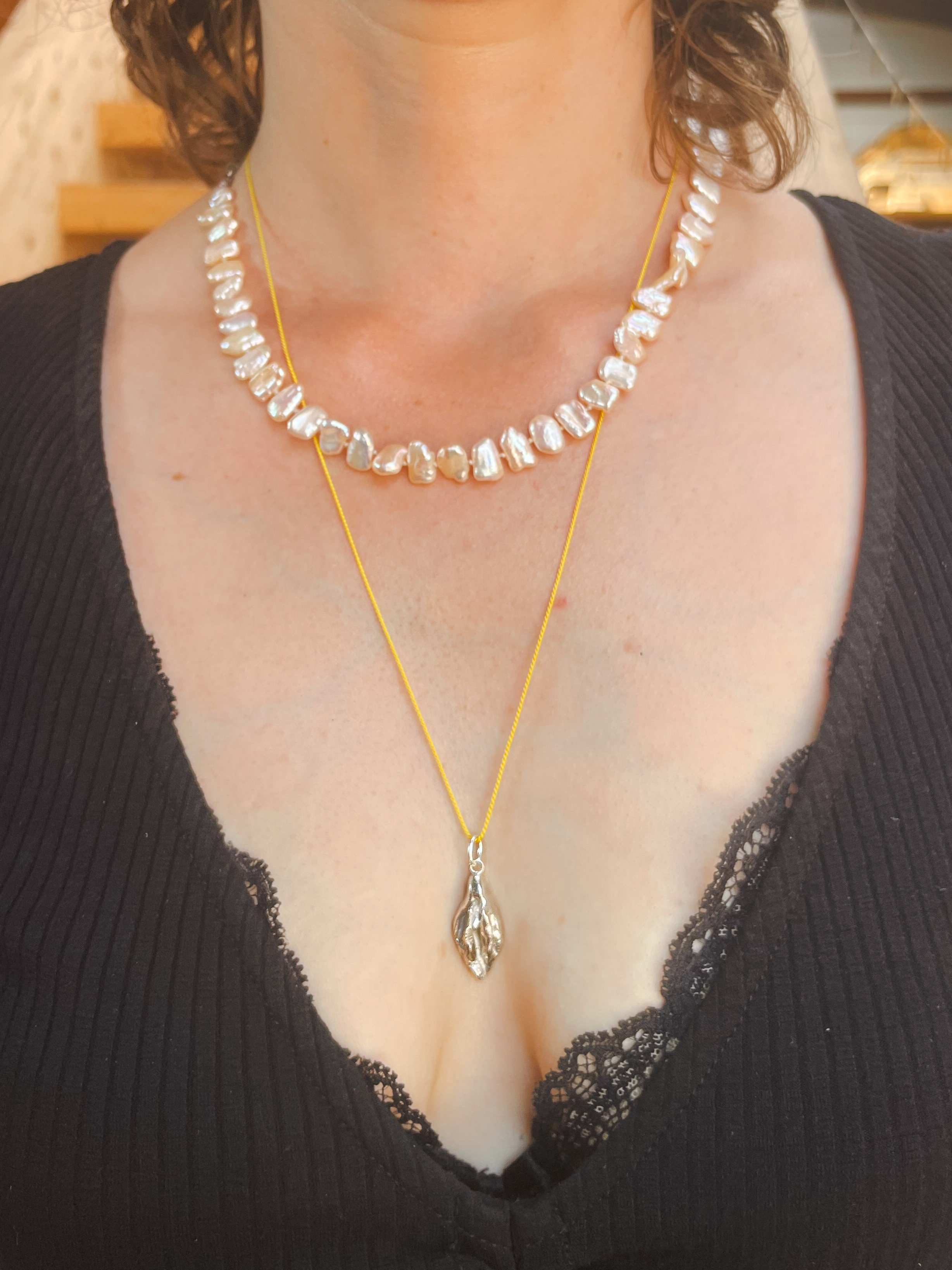 Silver Vulva necklace worn after the workshop