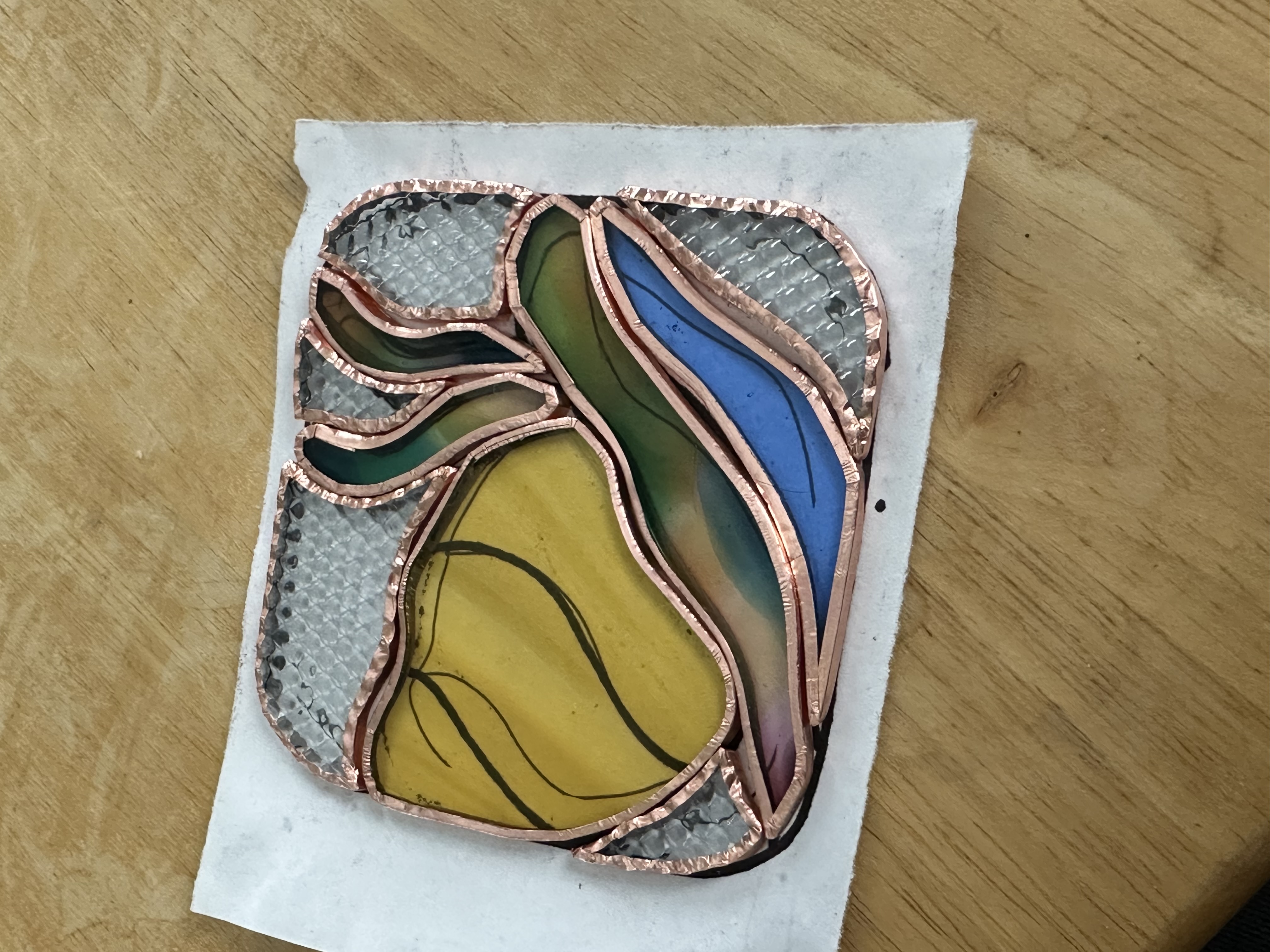 My pattern of glass pieces that have been ground are now wrapped in copper foil along the edges