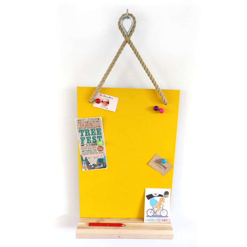 Bright yellow magnetic board hung from hemp rope with steel thimble