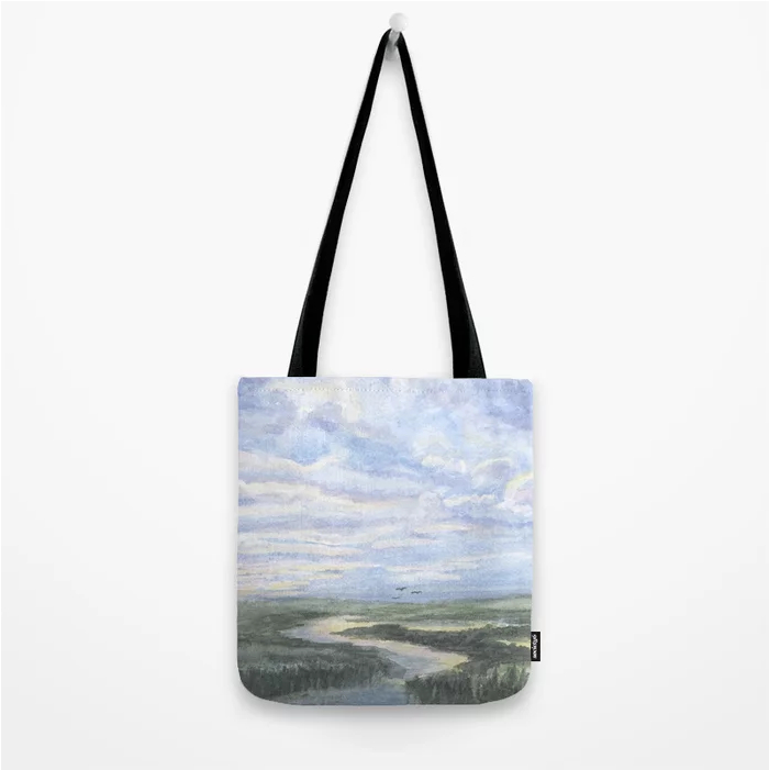 Tote featuring a watercolor painting of a vast landscape with a winding river.