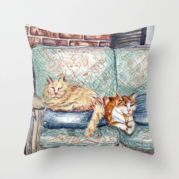 A square decorative pillow featuring a pen drawing of two cats resting on a bench.