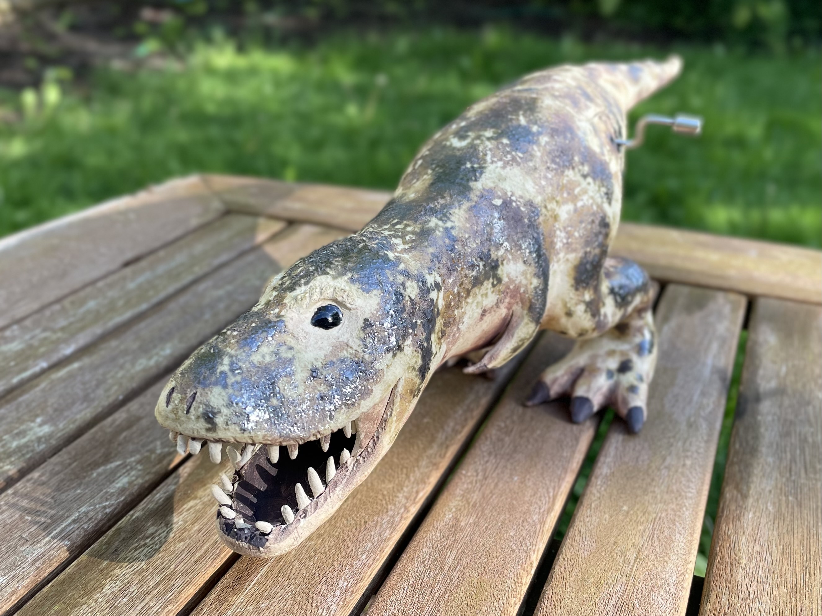 Ceramic Tyrannosaurus rex glazed with mottled brown and green.