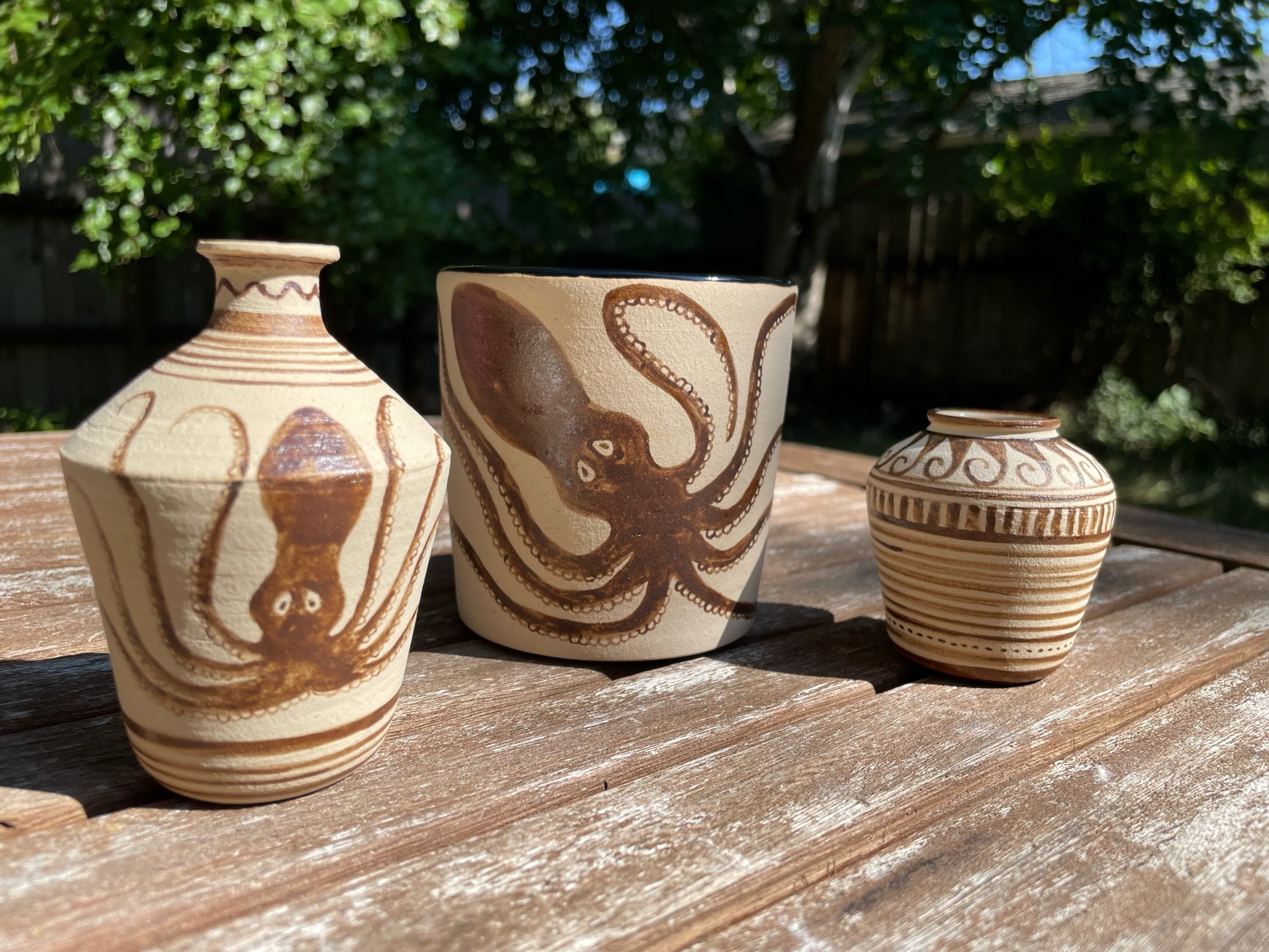 Three vases of different shapes and sizes with painted Minoan octopus designs.