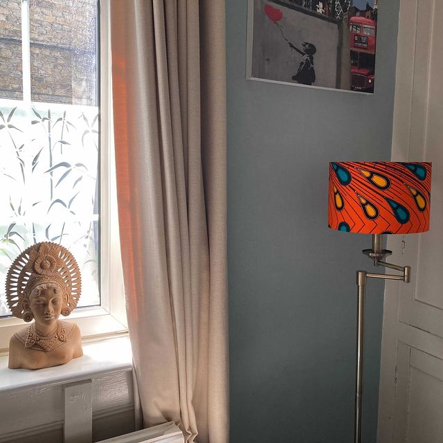 Orange African lampshade with peacock feathers handmde by Detola and Geek situated in a repeat customers home. Image credit @regalfbv (on instagram)