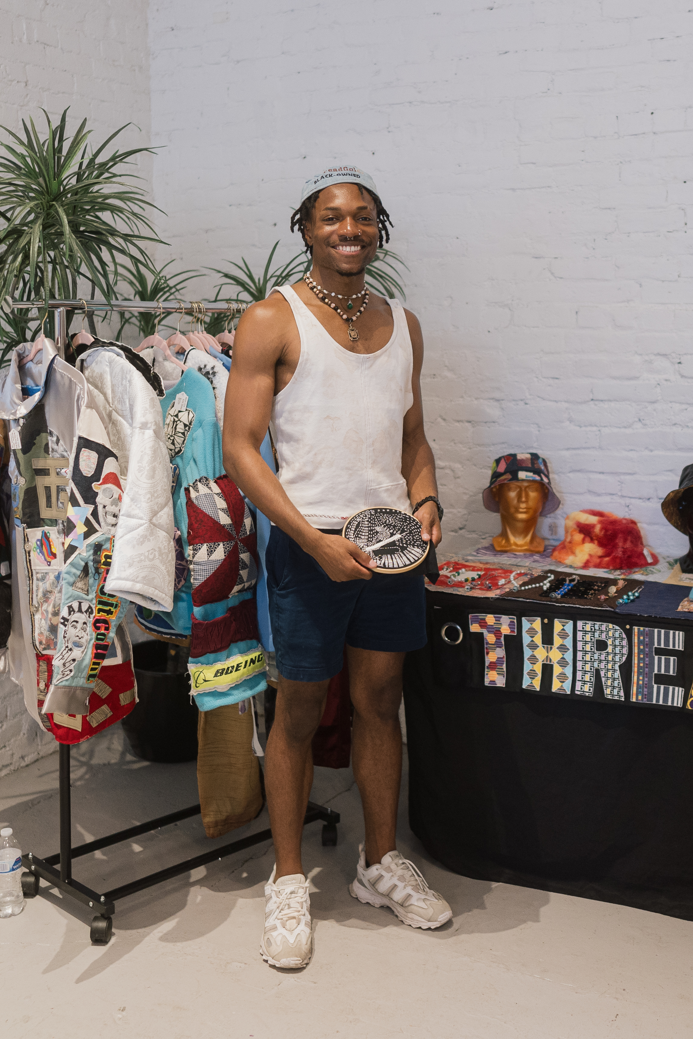 Abdul-Malik Ford standing in front of the ThreadGoldz vendor booth at the 210Seattle Night Market