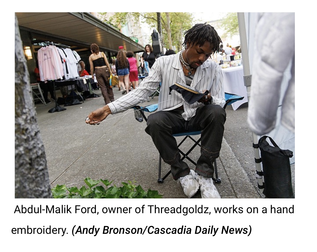 Abdul-Malik Ford working on a hand embroidery next to the ThreadGoldz booth a block party in Bellingham, WA.