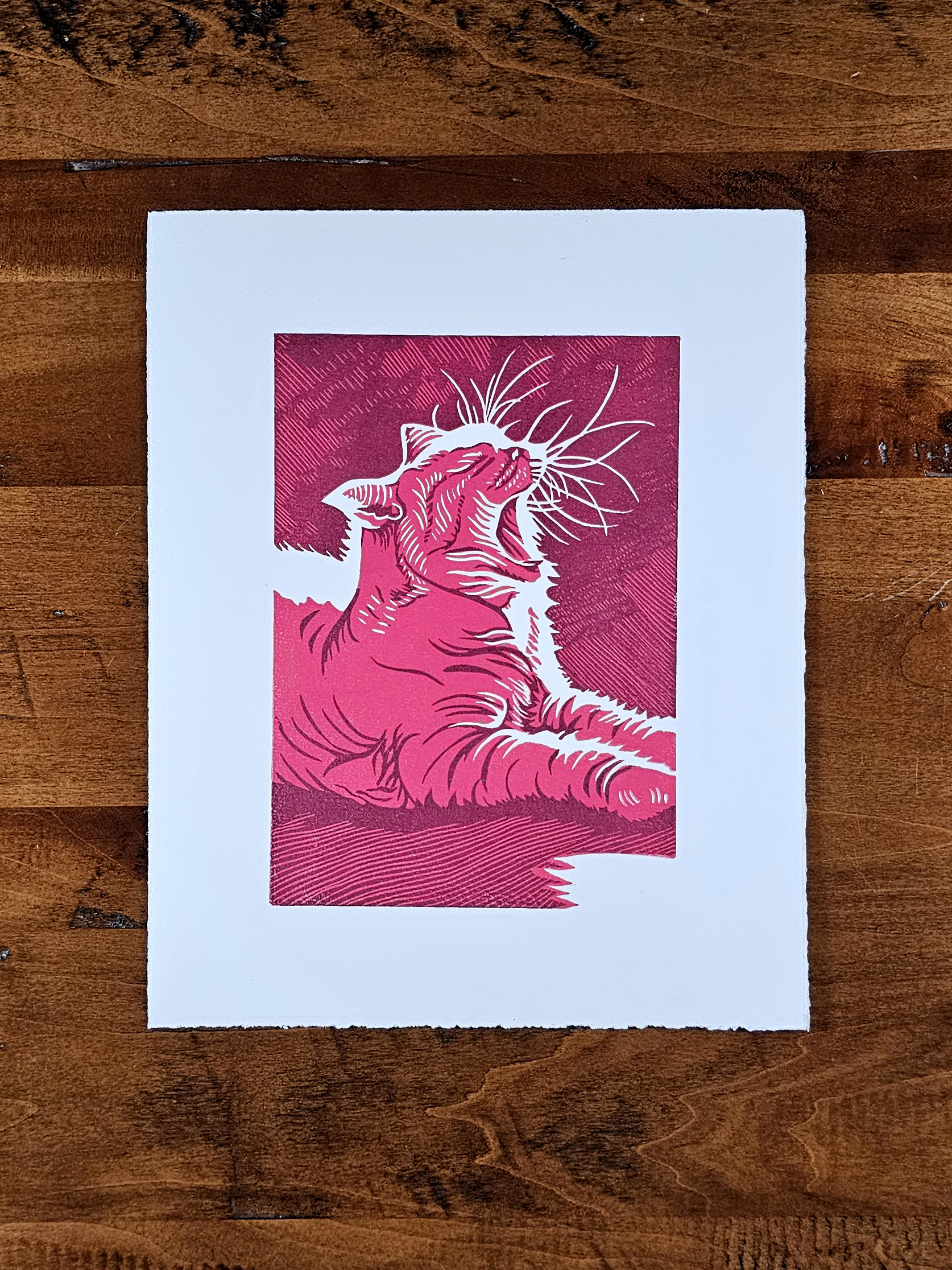 Linoleum block print of a cat in a sunspot in red