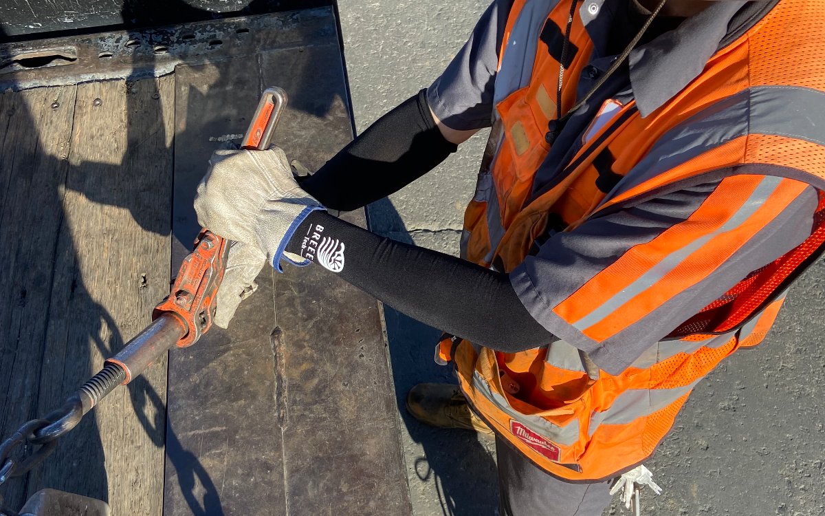 yard worker using sleeves to unchain binders