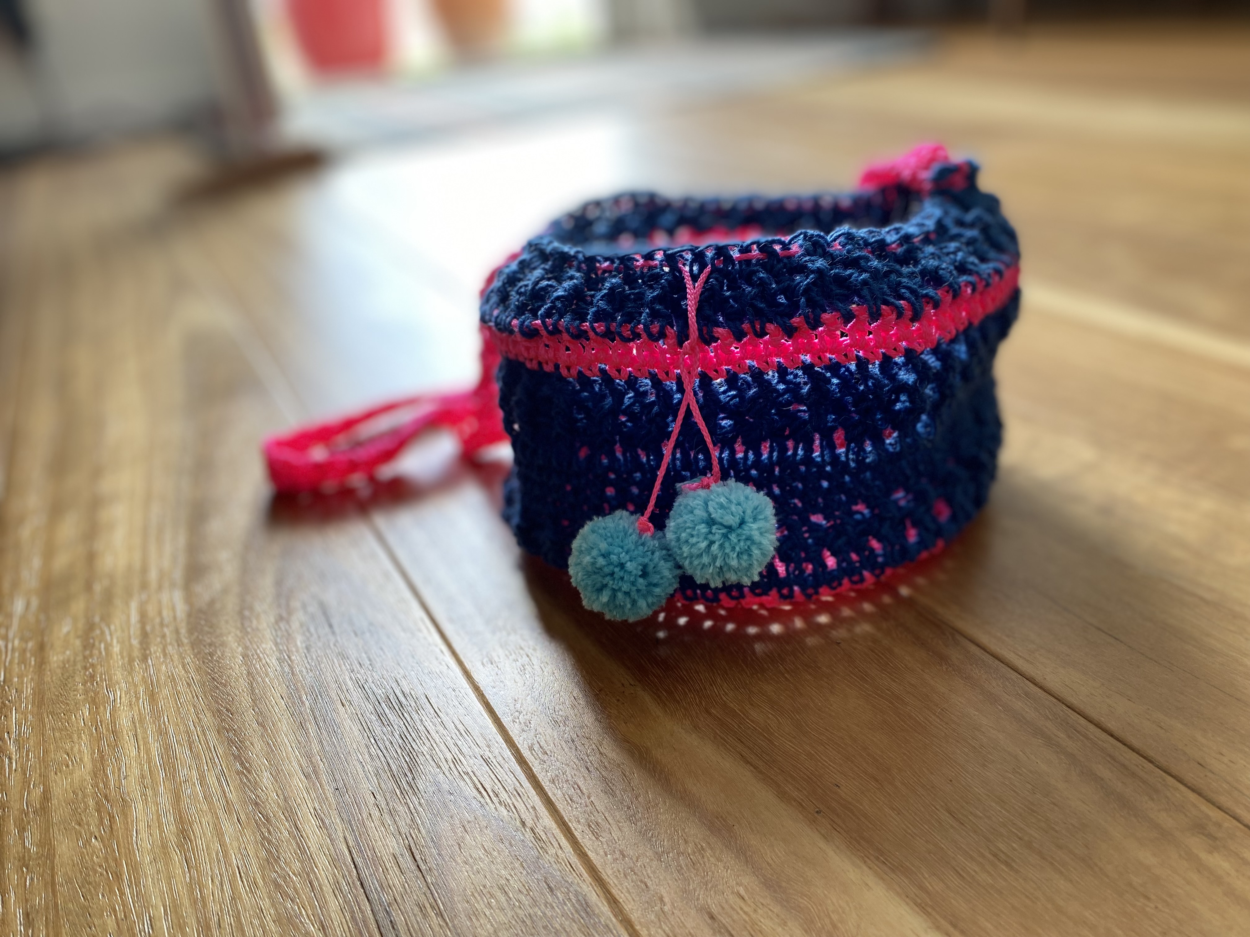 crocheted basket with trap and pom pom