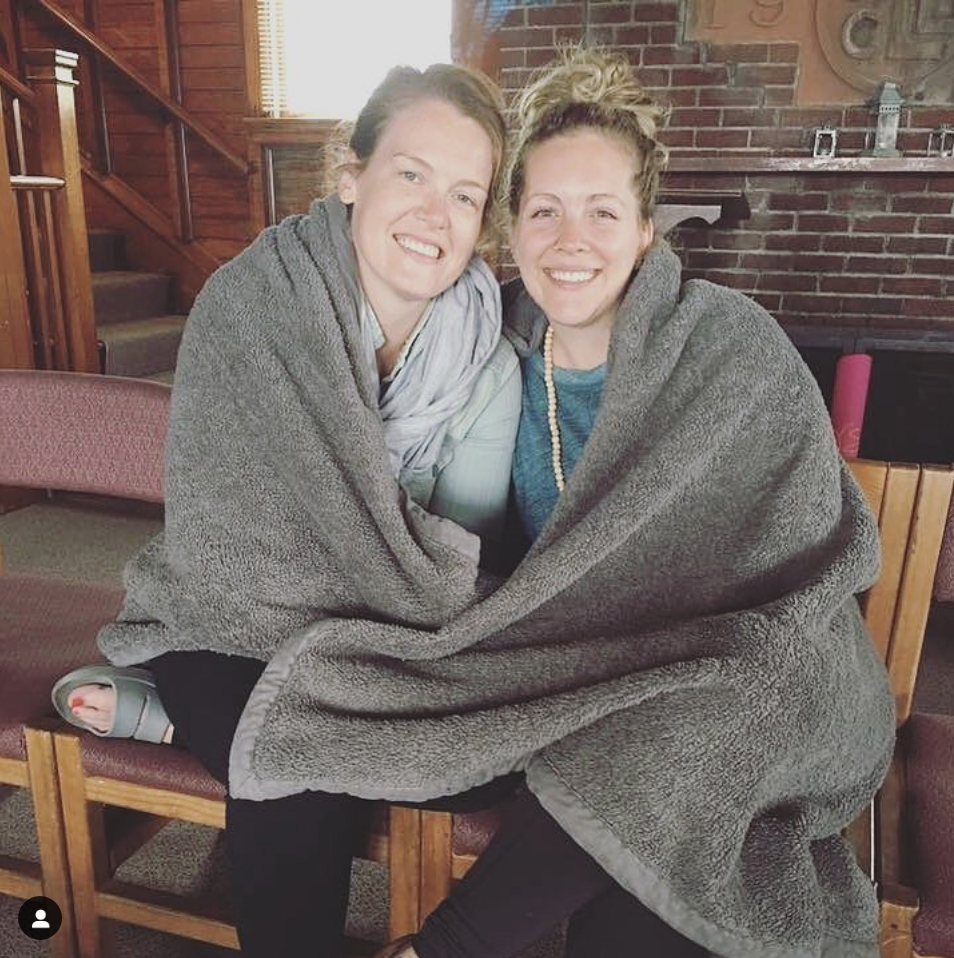 Ellie and Sarah at the yoga retreat snuggled together in a blanket