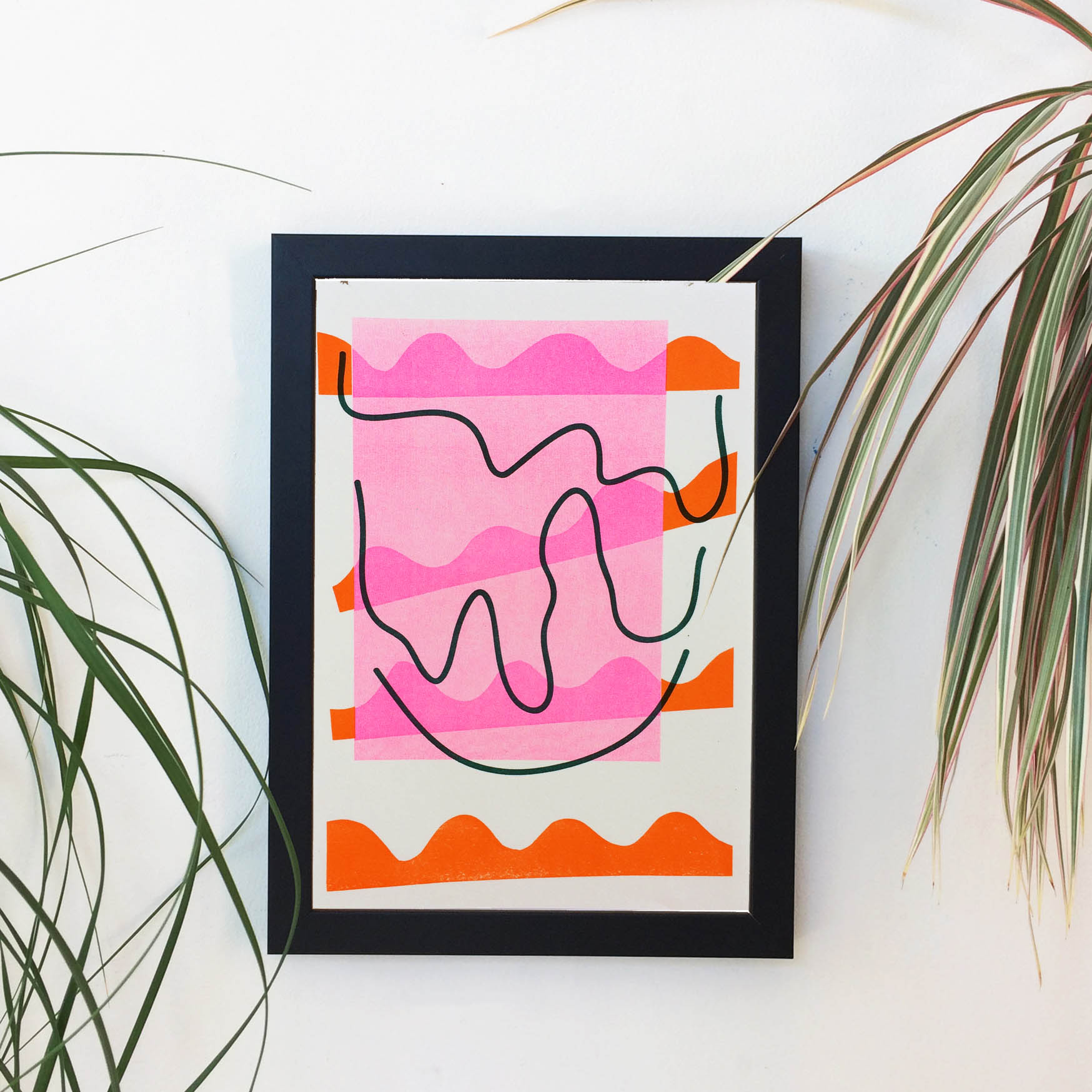 An abstract wiggly print in a frame in orange pink and teal