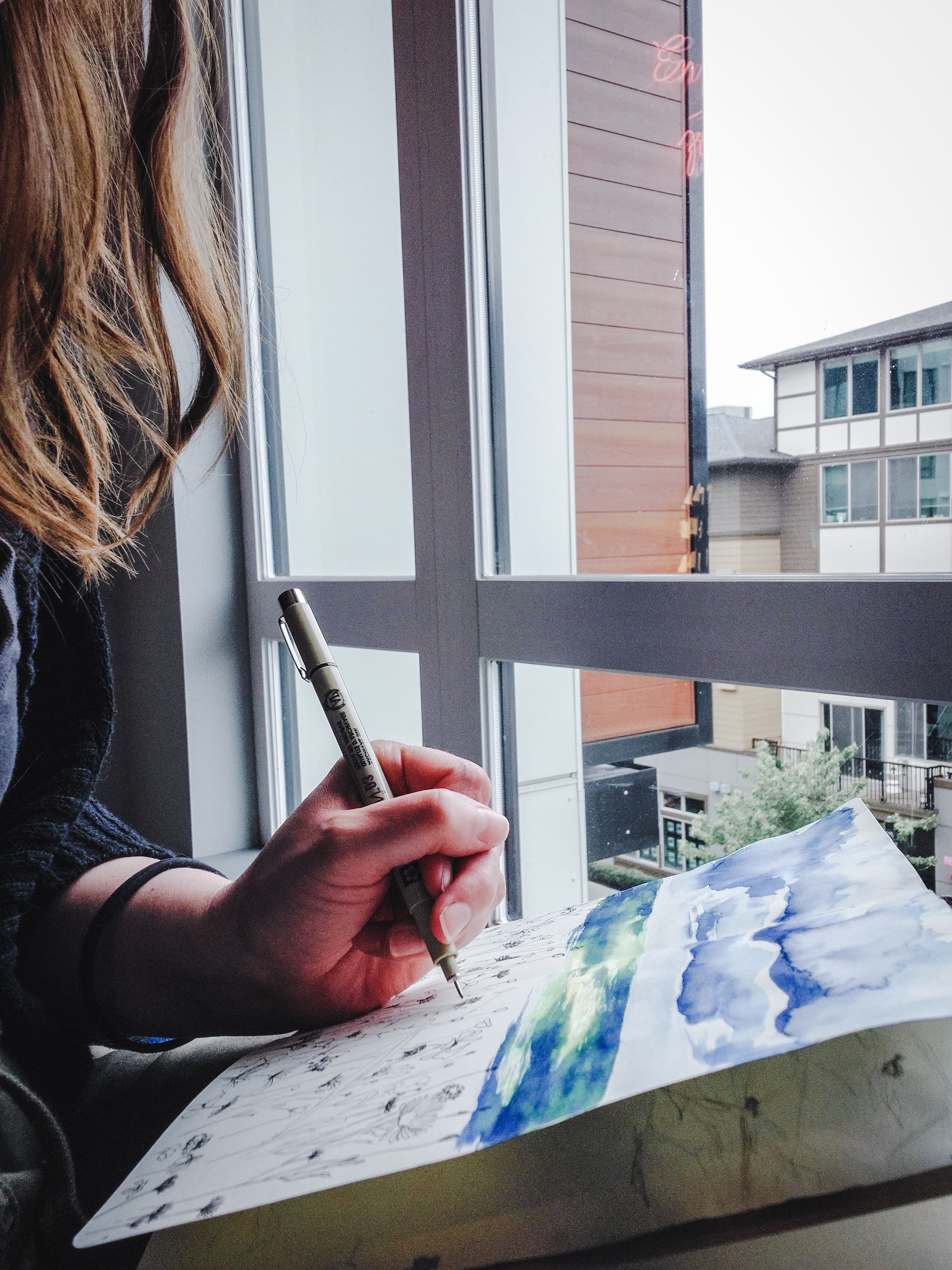 Pacific Northwest artist Jessika Kearns works on a watercolor and ink mixed media drawing in her sketchbook