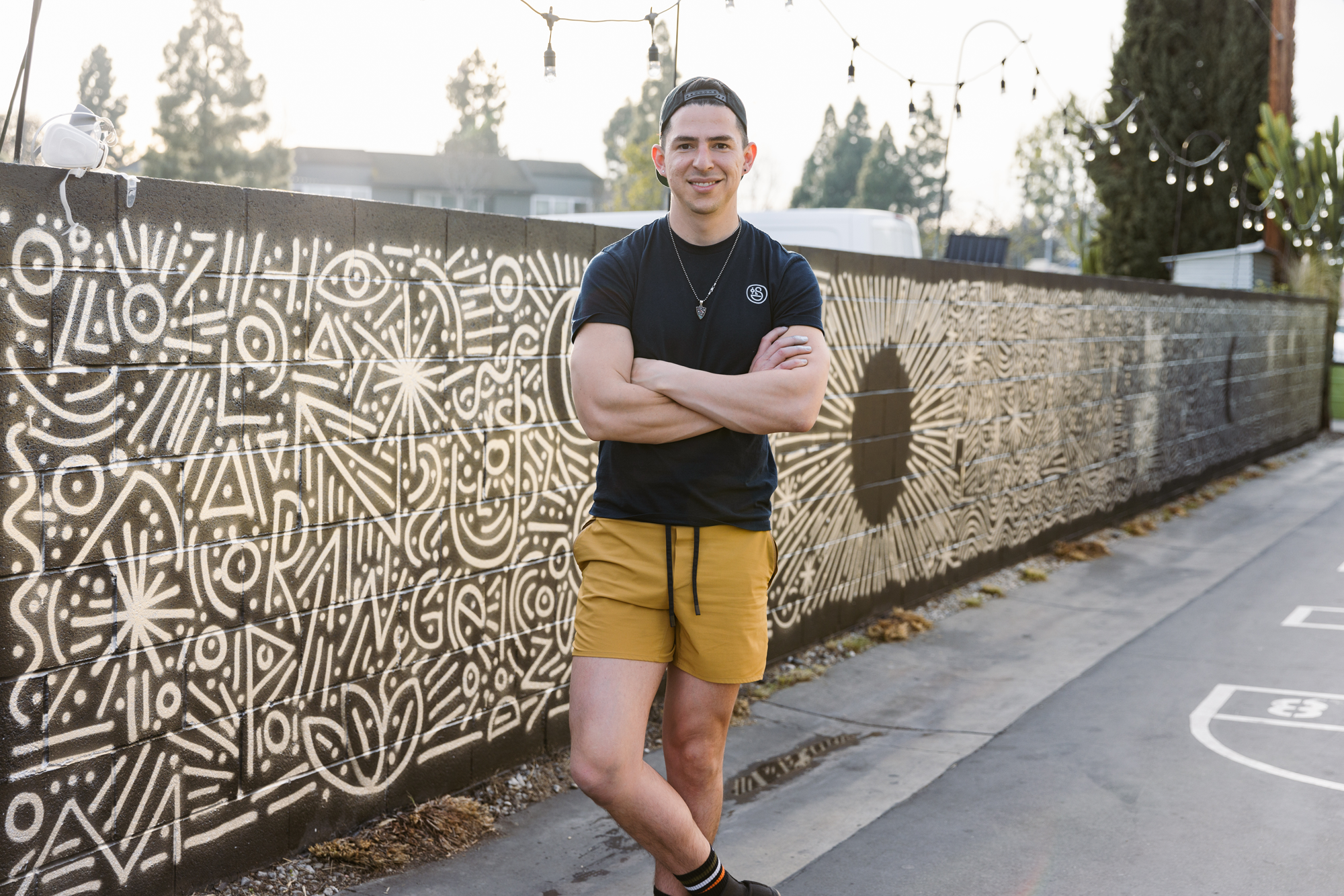 Charlo standing in front of one of his murals. 