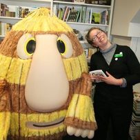 Smiling white woman with book character Grug