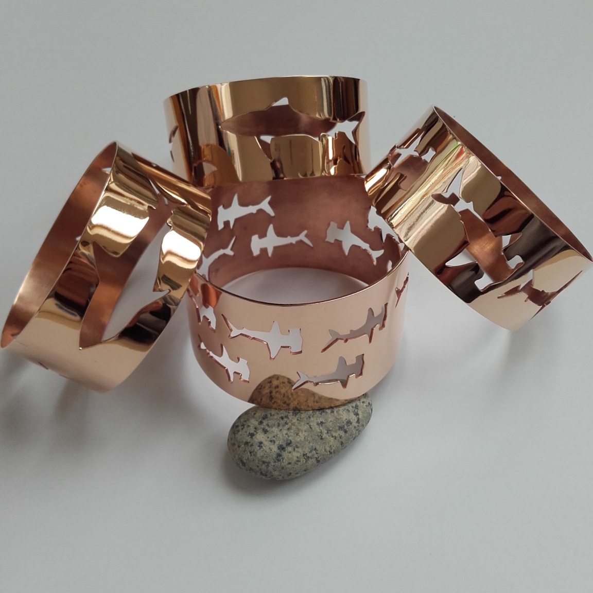 Four bronze bangles with shark pattern cut outs