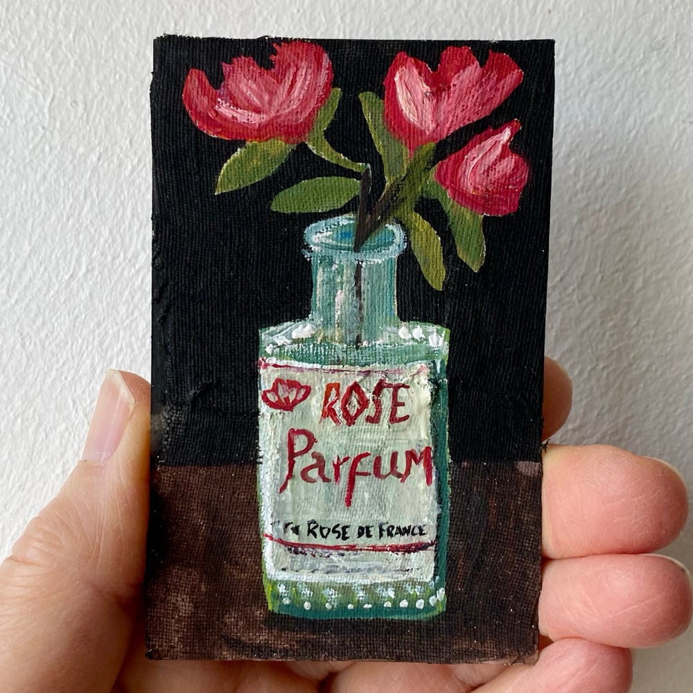 Image of roses in an old perfume bottle