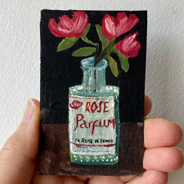 Image of roses in an old perfume bottle