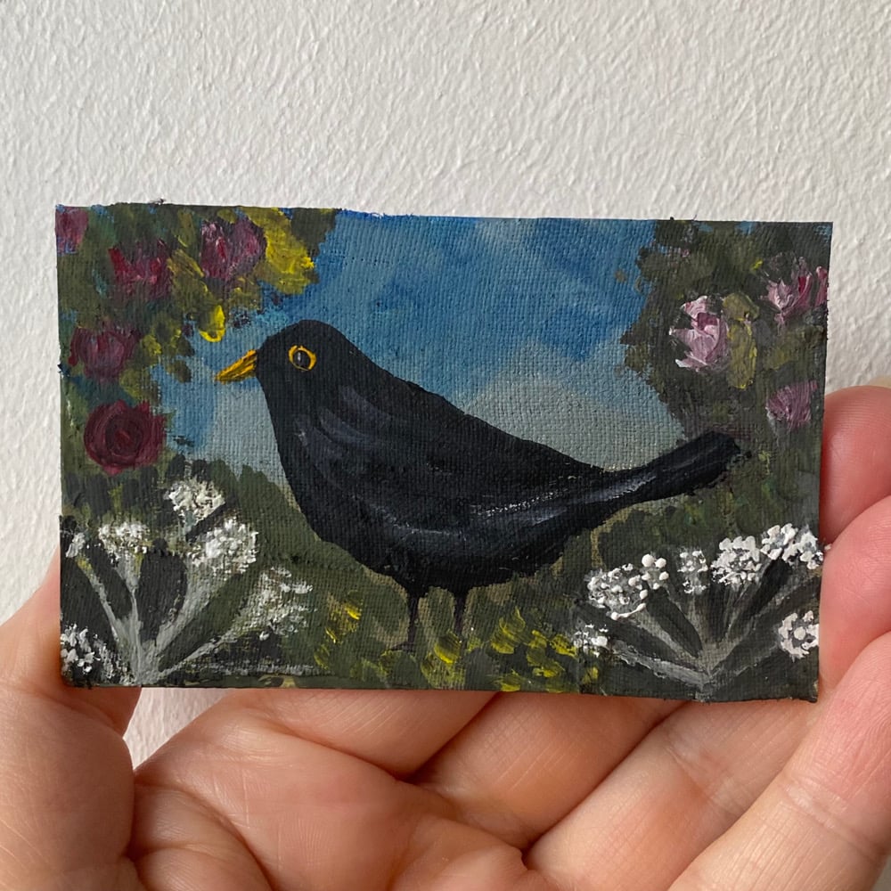 Image of a blackbird with roses and yarrow