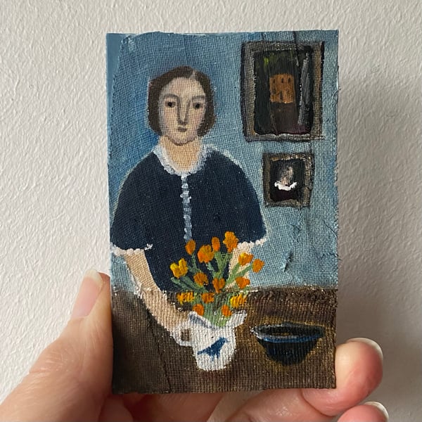 Image of Woman in a blue room with marigolds 