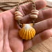Image of Hawaiian sunrise shell necklace with golden pukas and a locking seaglass clasp