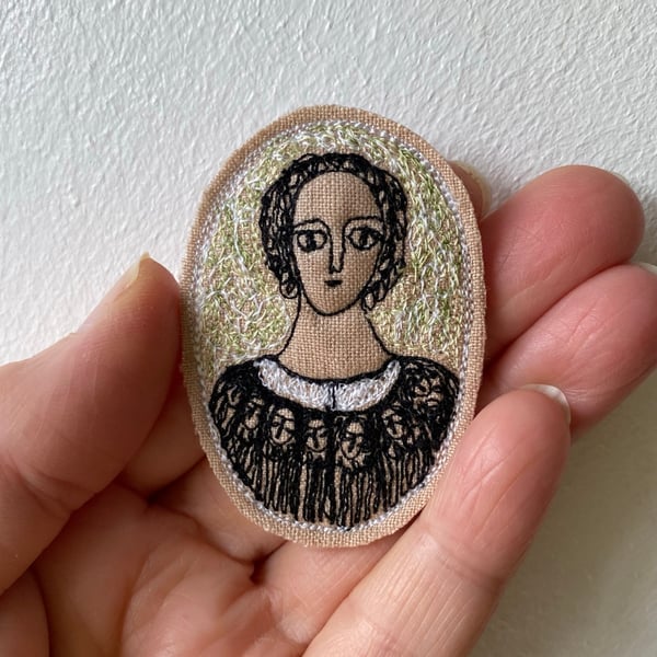 Image of woman in black, in a garden - embroidery brooch 