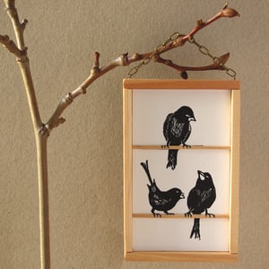 Image of Hanging print of an original linocut image of three free black birds.