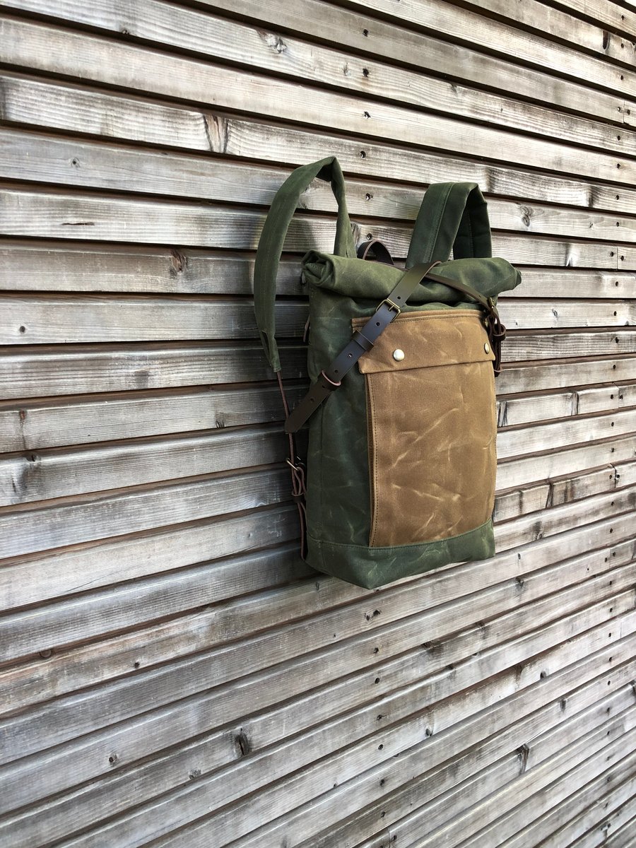Image of olive green backpack medium size rucksack in waxed canvas, with volume front pocket and double layer