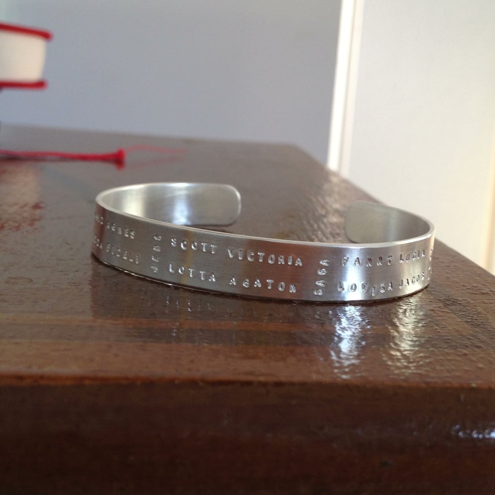 Image of Silver cuff with text pattern