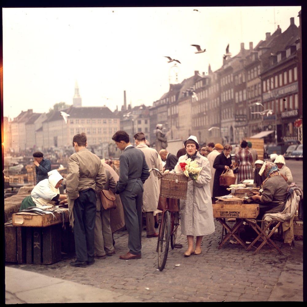 Image of A woman in postwar Denmark walking through an open air market