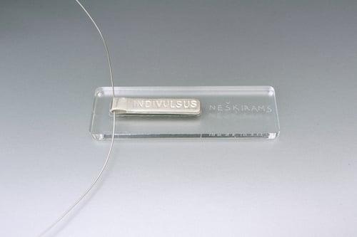 Image of silver pendant with inscription in Latin