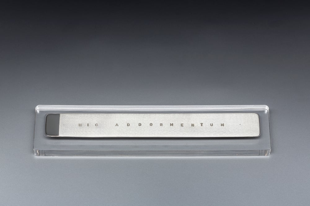 Image of silver bookmark with a Latin inscription