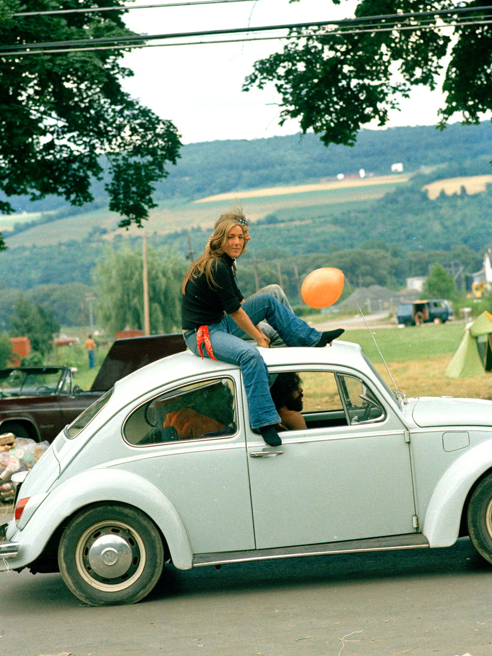 Image of Woman Catches A Ride Through A Rock Festival; Early 1970s