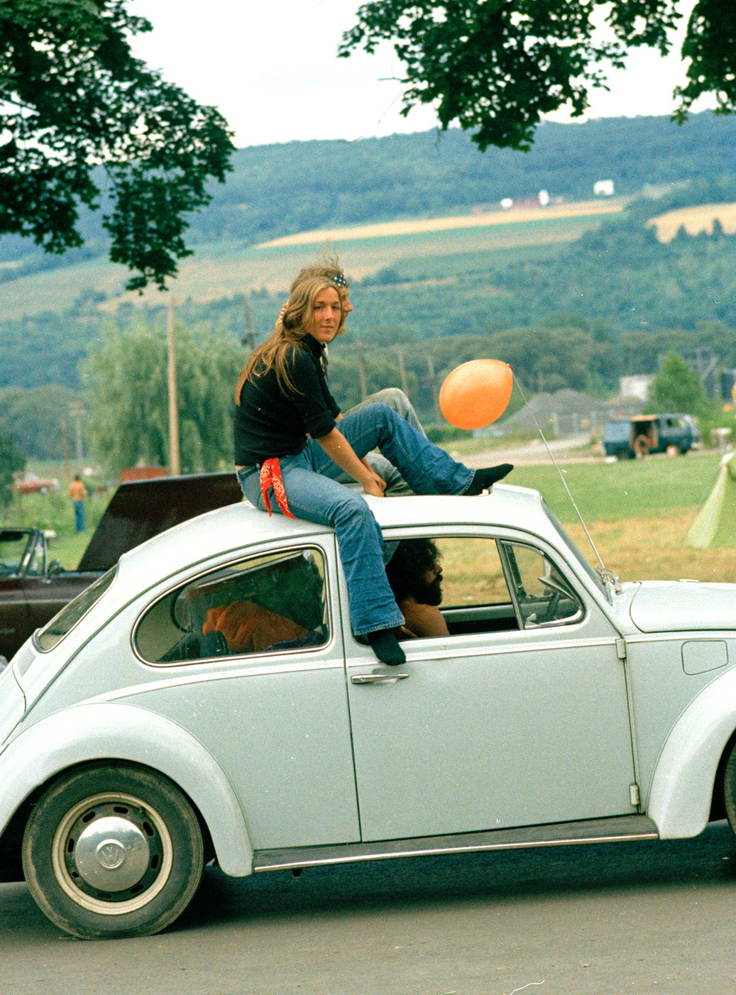 Image of Woman Catches A Ride Through A Rock Festival; Early 1970s