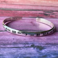 Image 1 of 'Luna' symbol stamped cuff bracelet. Slim silver Aztec patterned cuff bracelet. 