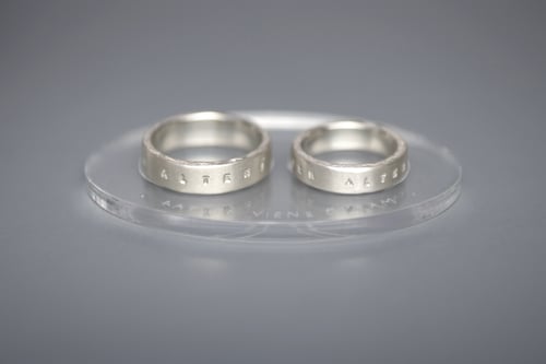 Image of silver wedding rings with inscription in Latin