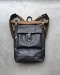 Image 1 of Black leather backpack with waxed canvas roll to close top and leather front pocket