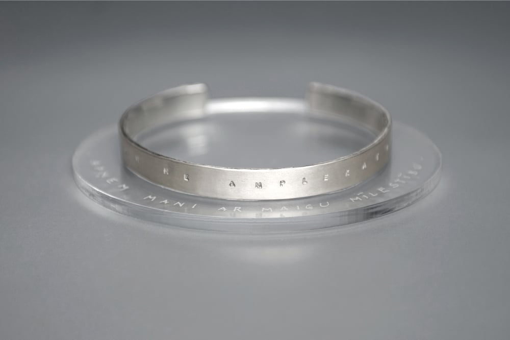 Image of silver bracelet with inscription in Latin