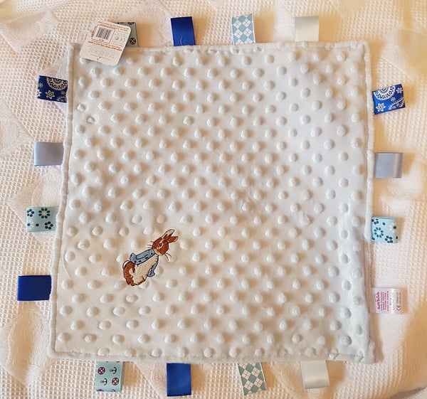 Image of peter rabbit taggie in blue or pink