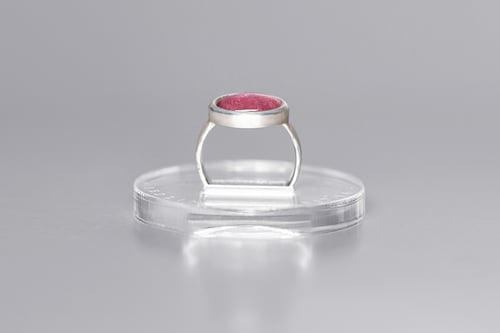 Image of silver ring with tourmaline and inscription in Latin