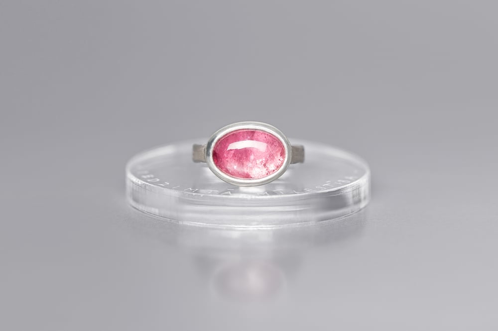 Image of silver ring with tourmaline and inscription in Latin