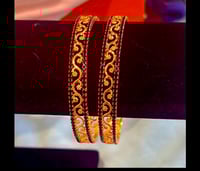 Image 1 of gold and black bangle 